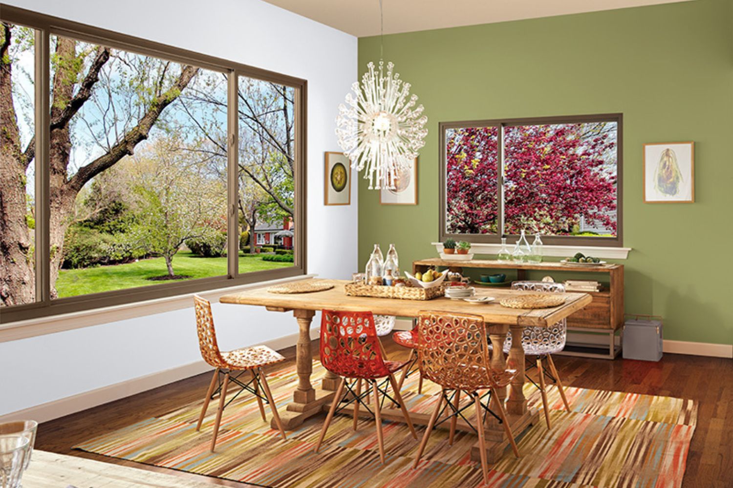 A dining room featuring a wooden table surrounded by chairs, set on a decorative rug.