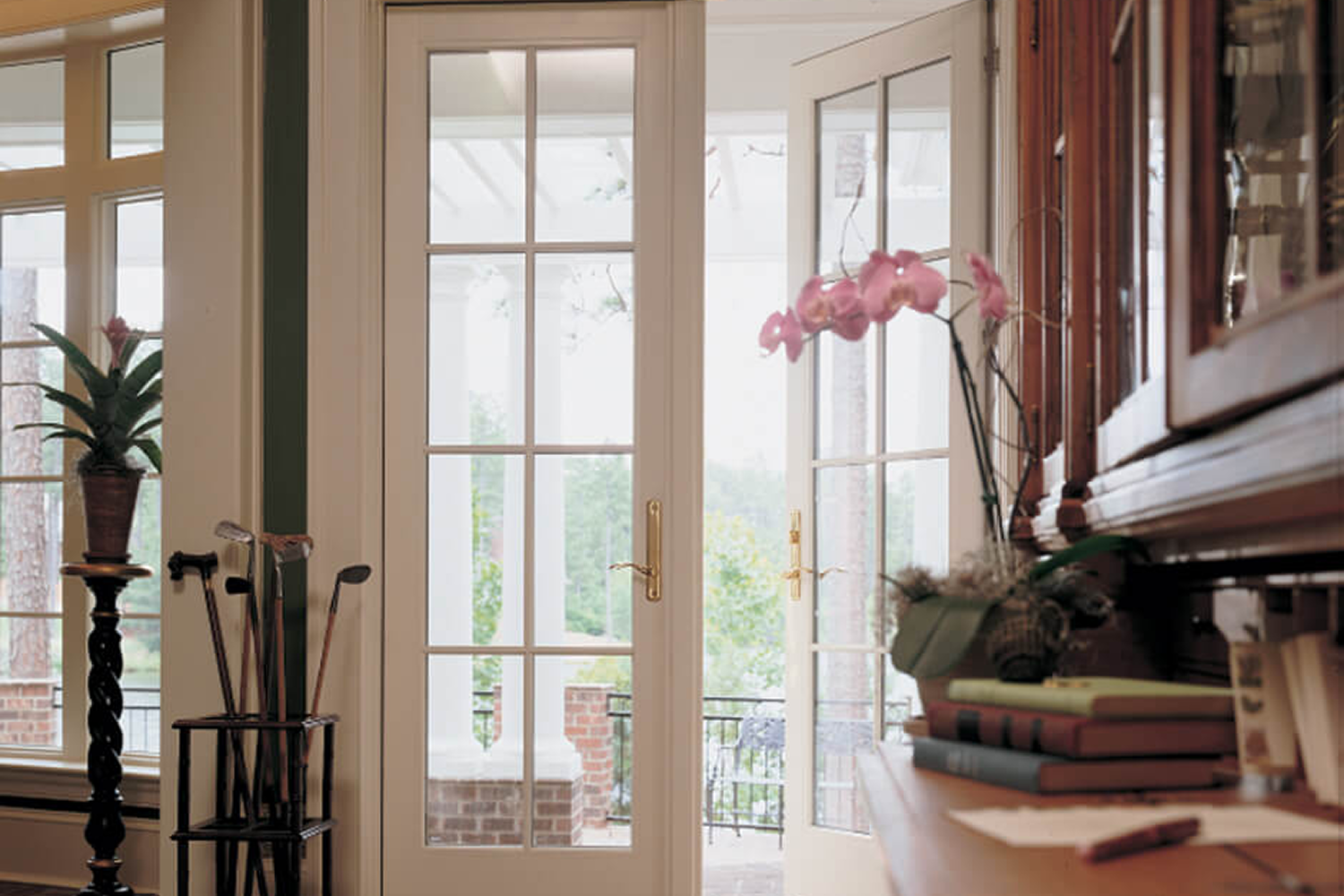 A set of white french doors in a living room that open to an outdoor patio.