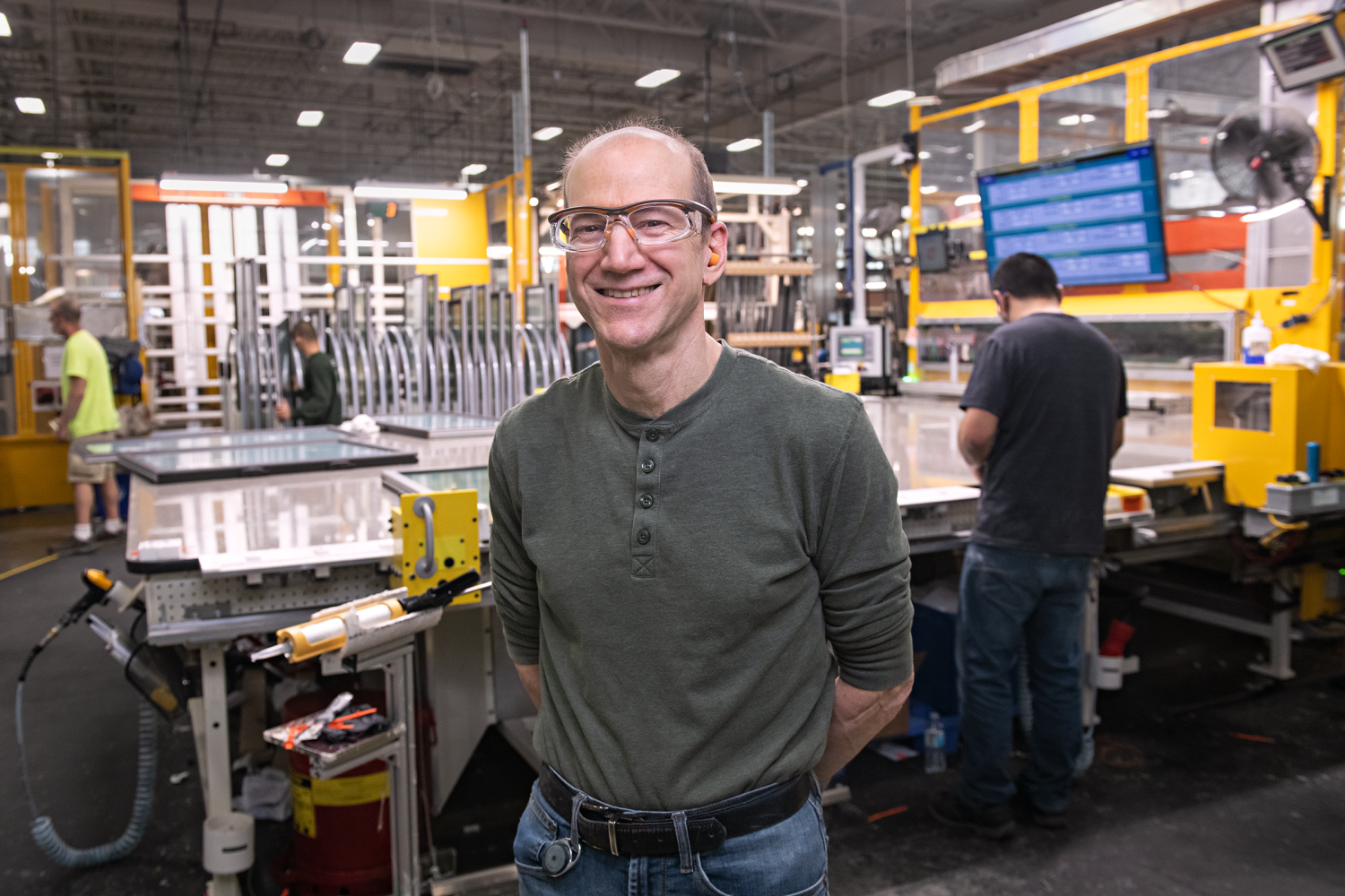 A Renewal by Andersen production association standing infront of a work station in the factory