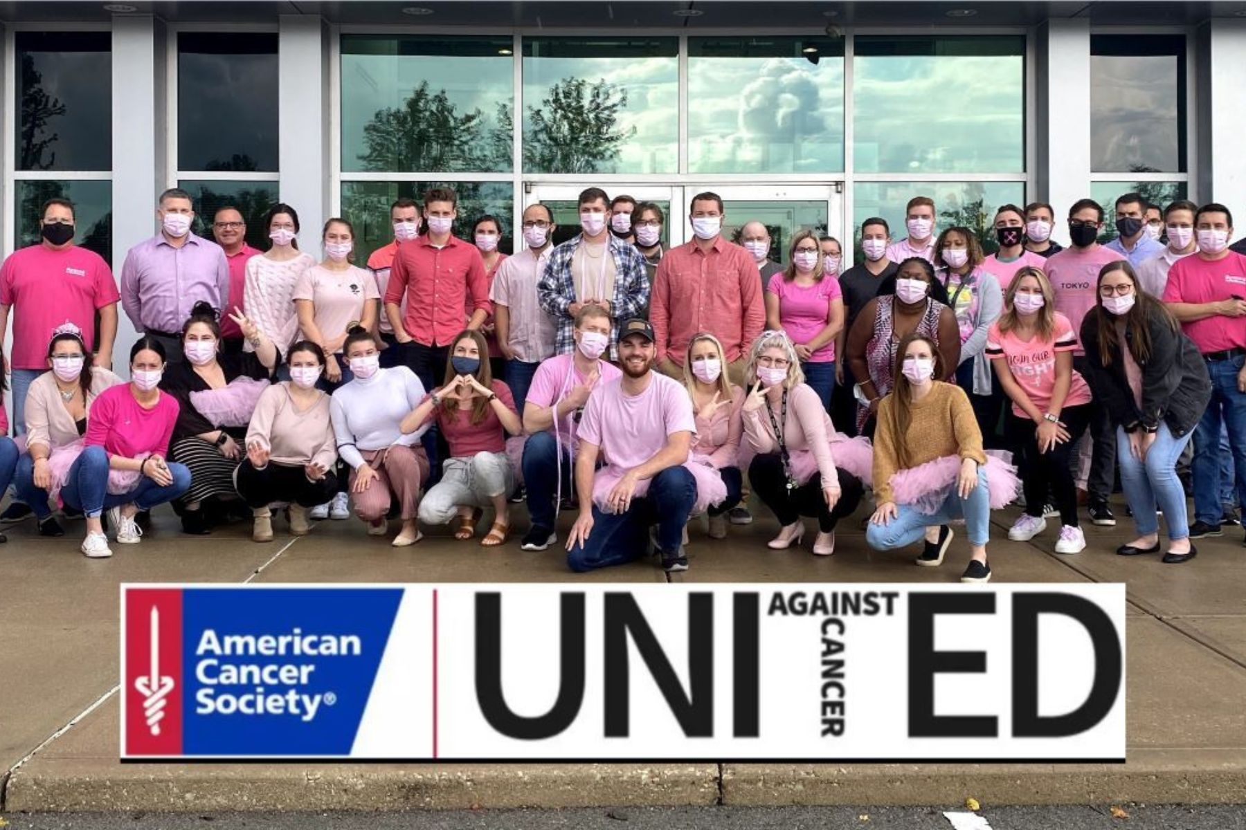 Group of RbA employees in pink shirts and masks showing support for ACS event.