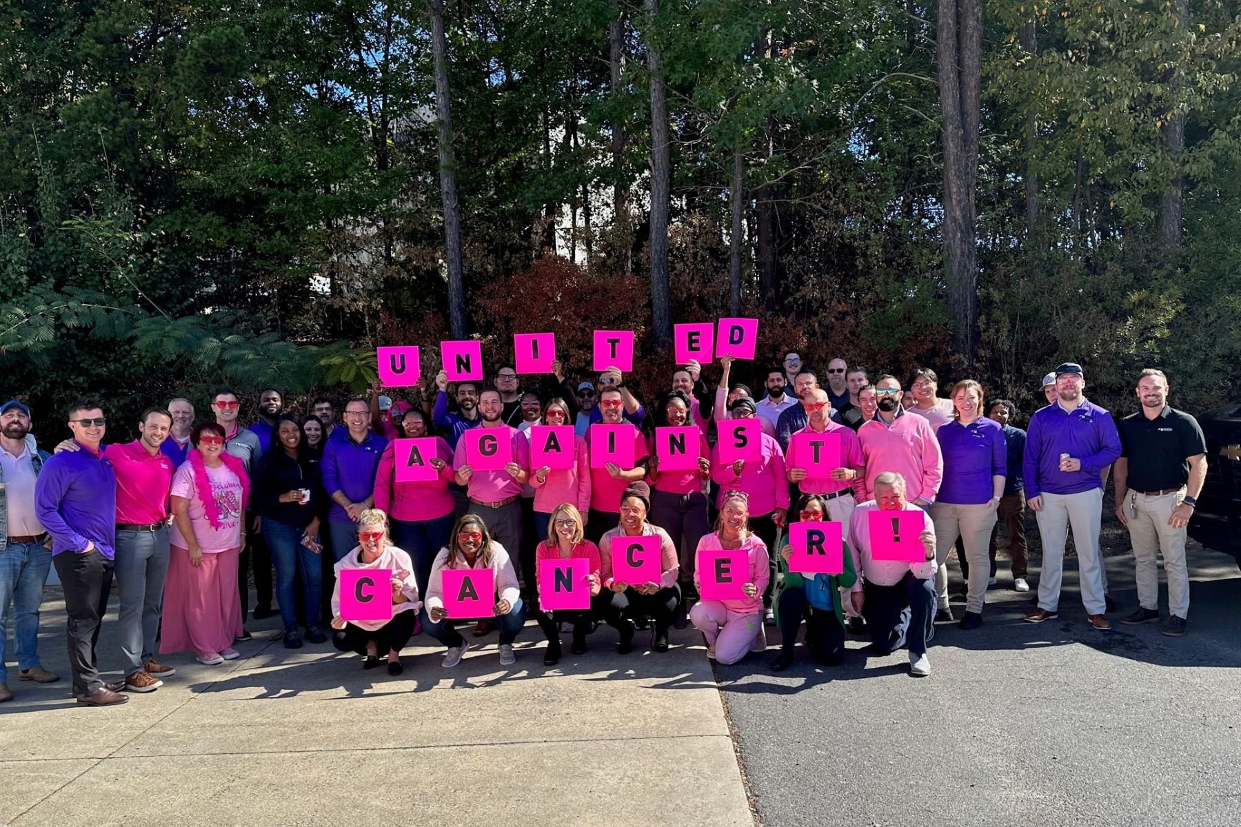 Group of RbA employees holding letters that spell out "United Against Cancer".