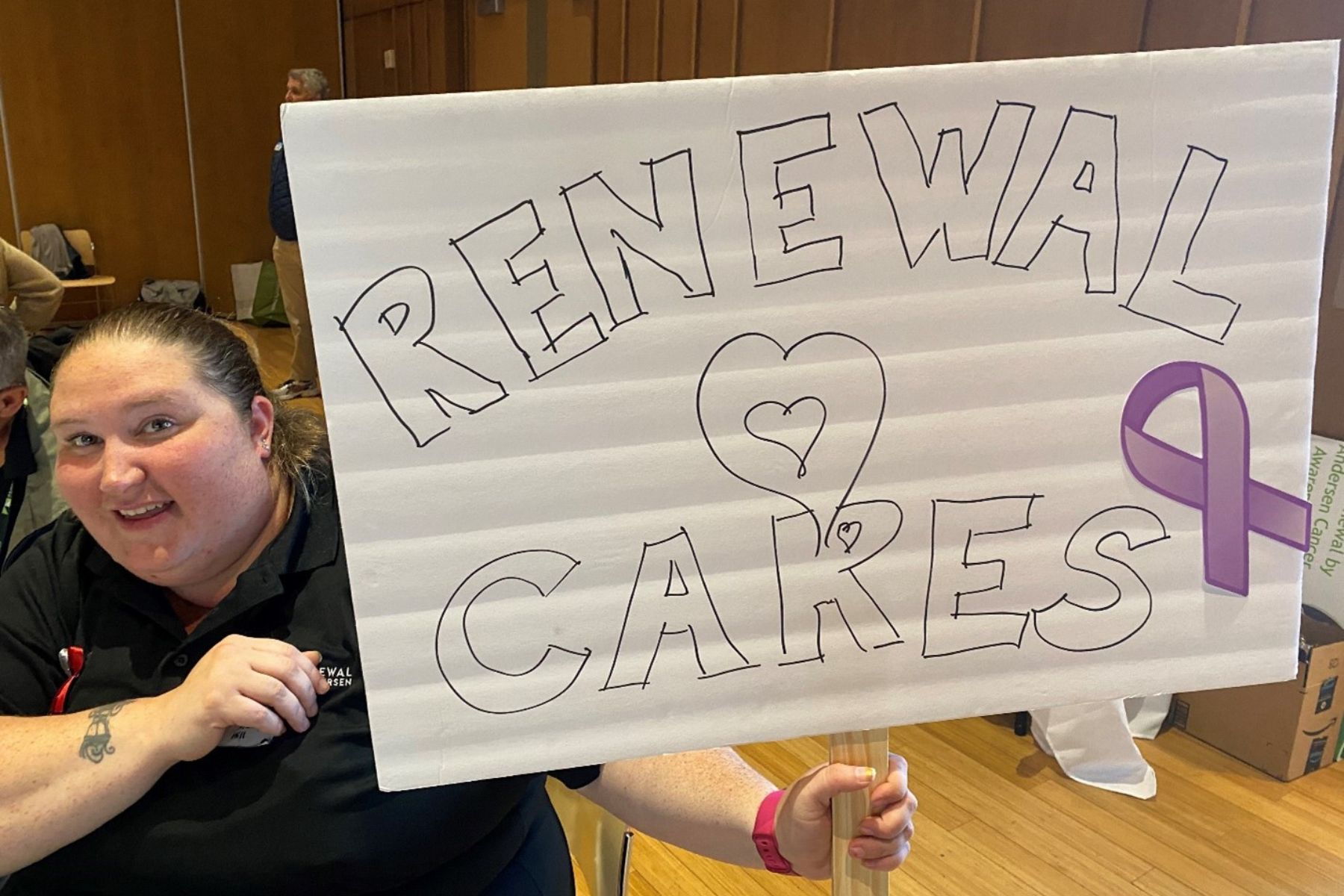 Woman holding a sign that reads "Renewal Cares" 