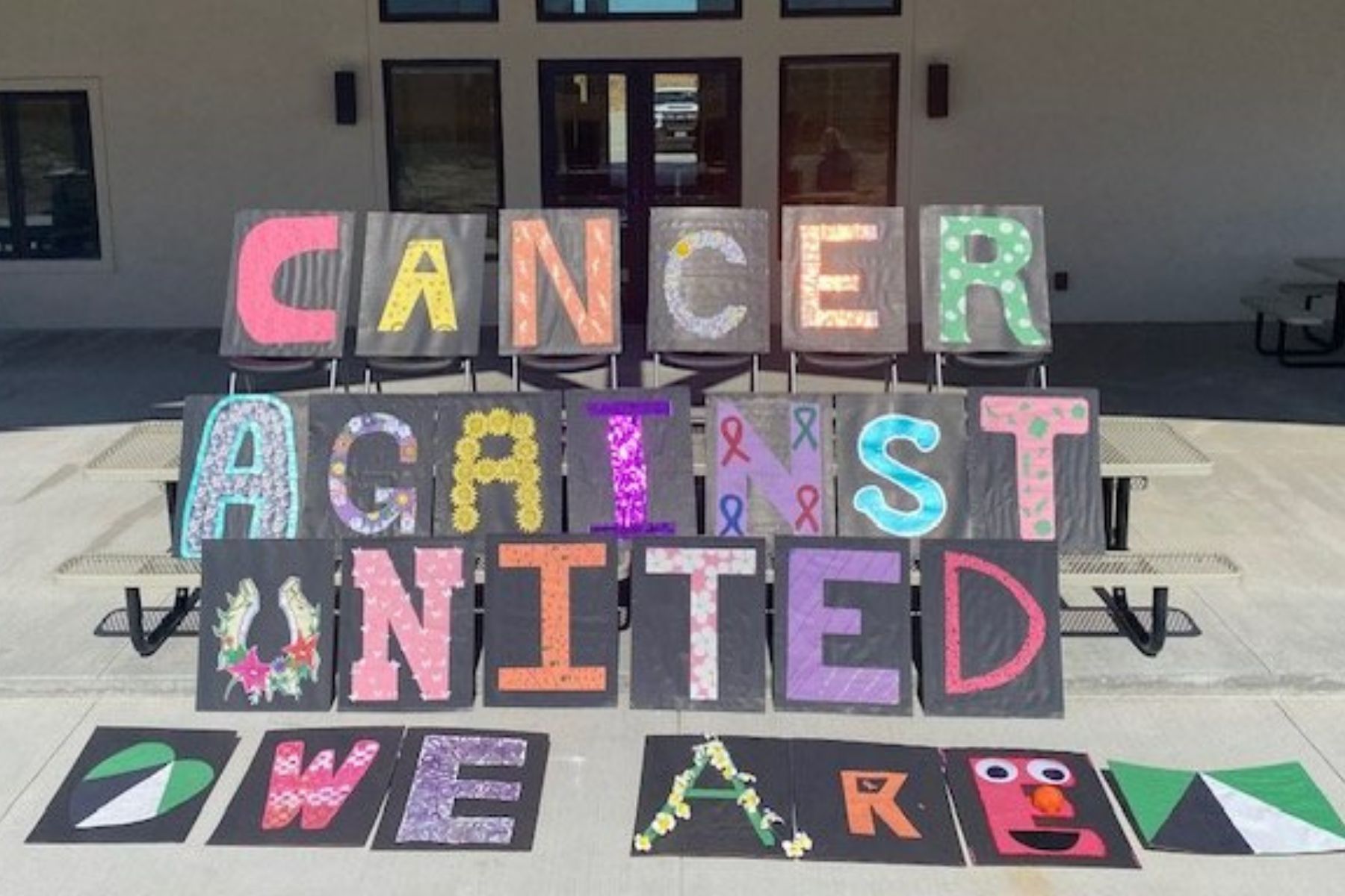 Letters made with colorful paper that spells out "We are united against cancer"