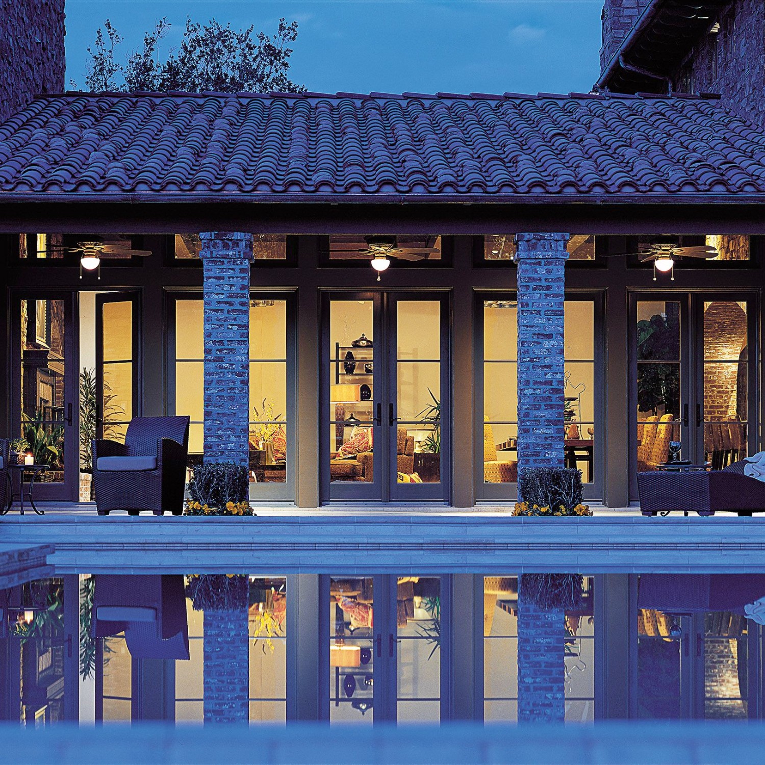 Terratone hinged French patio doors overlooking a swimming pool area.