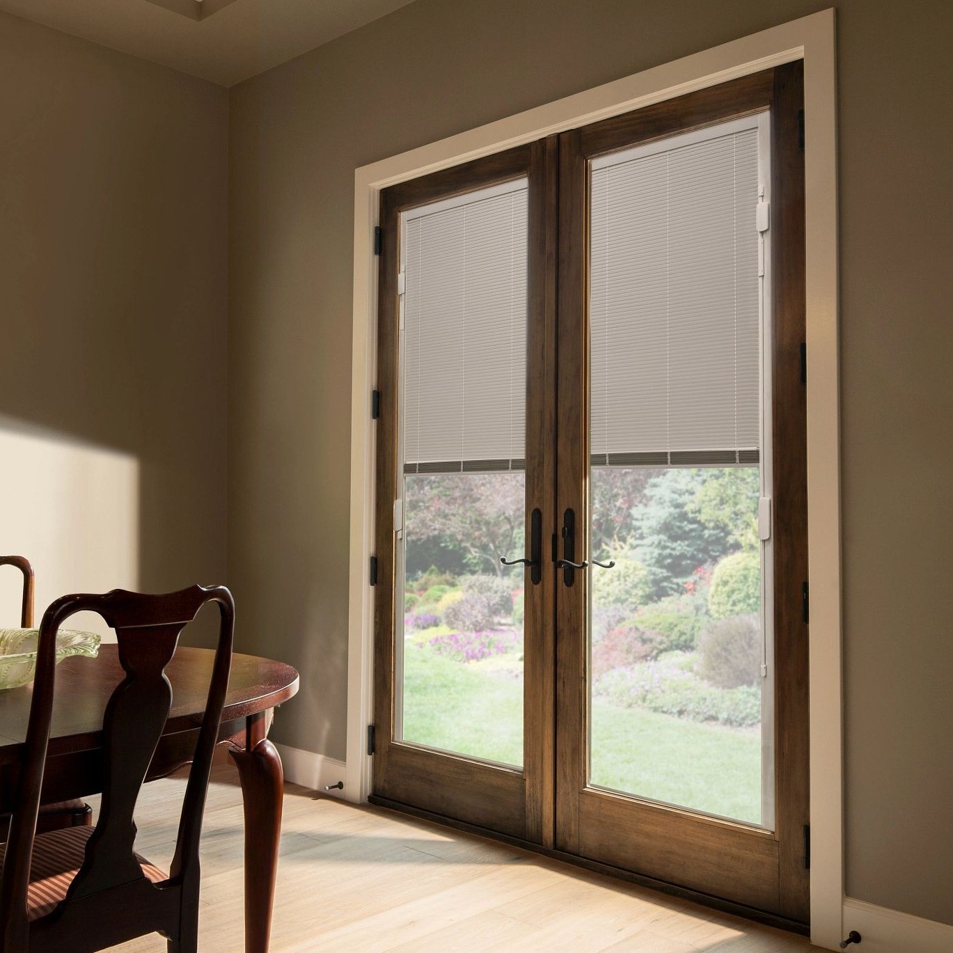Hinged French patio doors with blinds between the glass. The door has a wood finish.