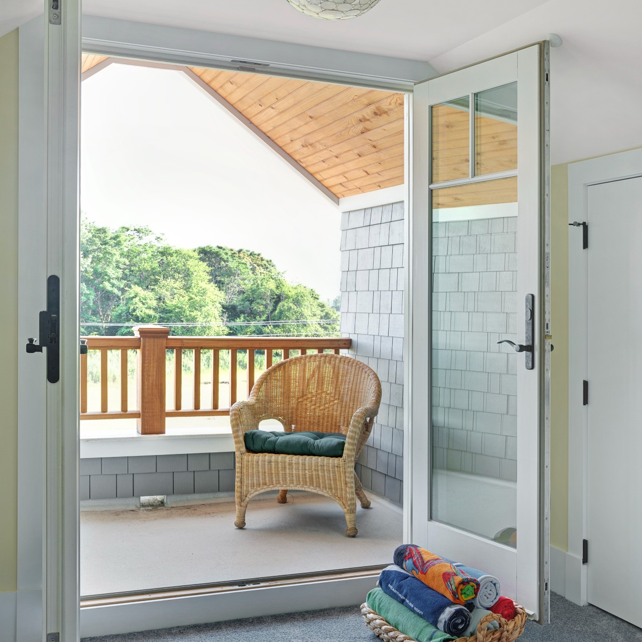 A pair of white French patio doors on a coastal front porch.