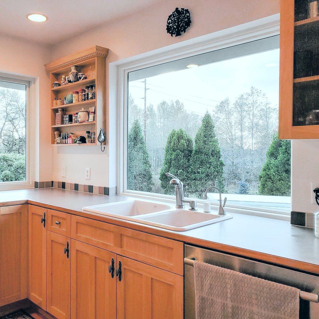 A washington state home with a large kitchen window. The view outside is foggy.