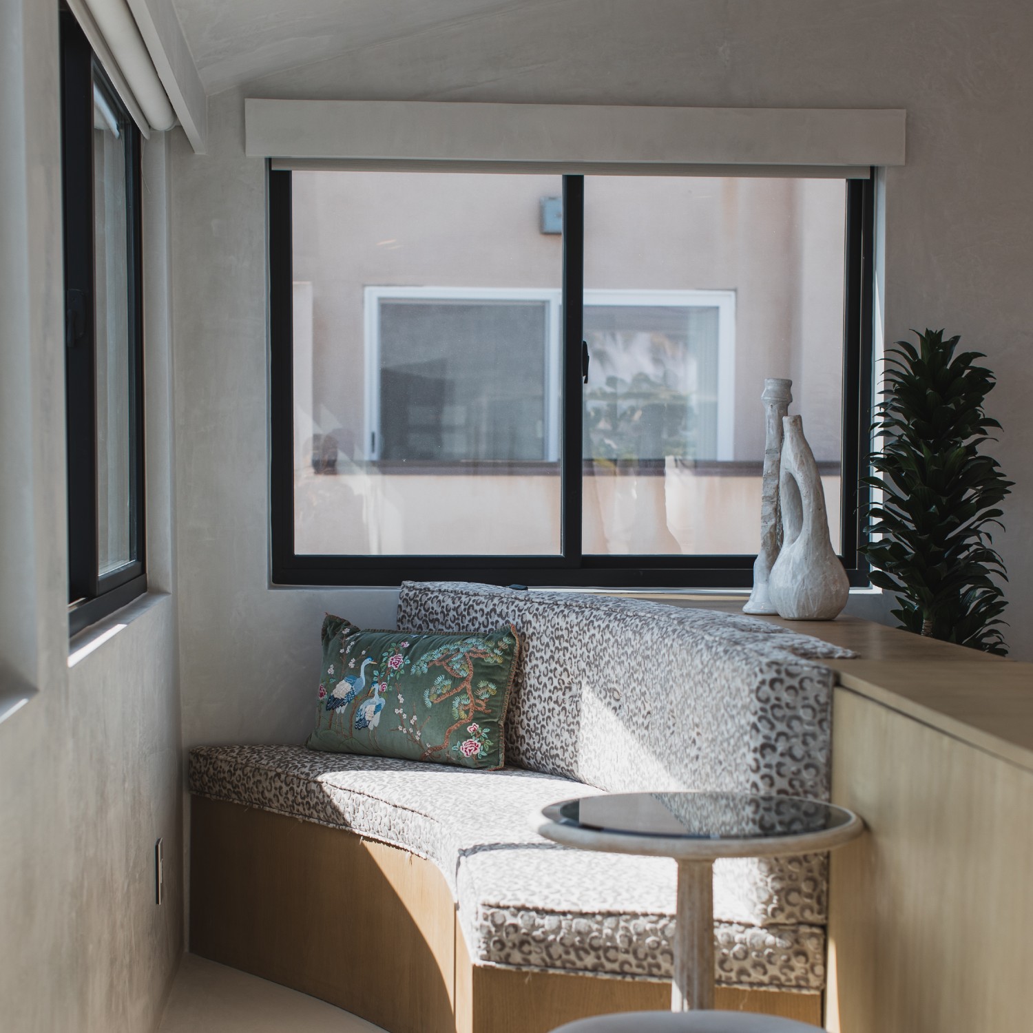 A cozy reading nook with a black framed gliding or sliding window.