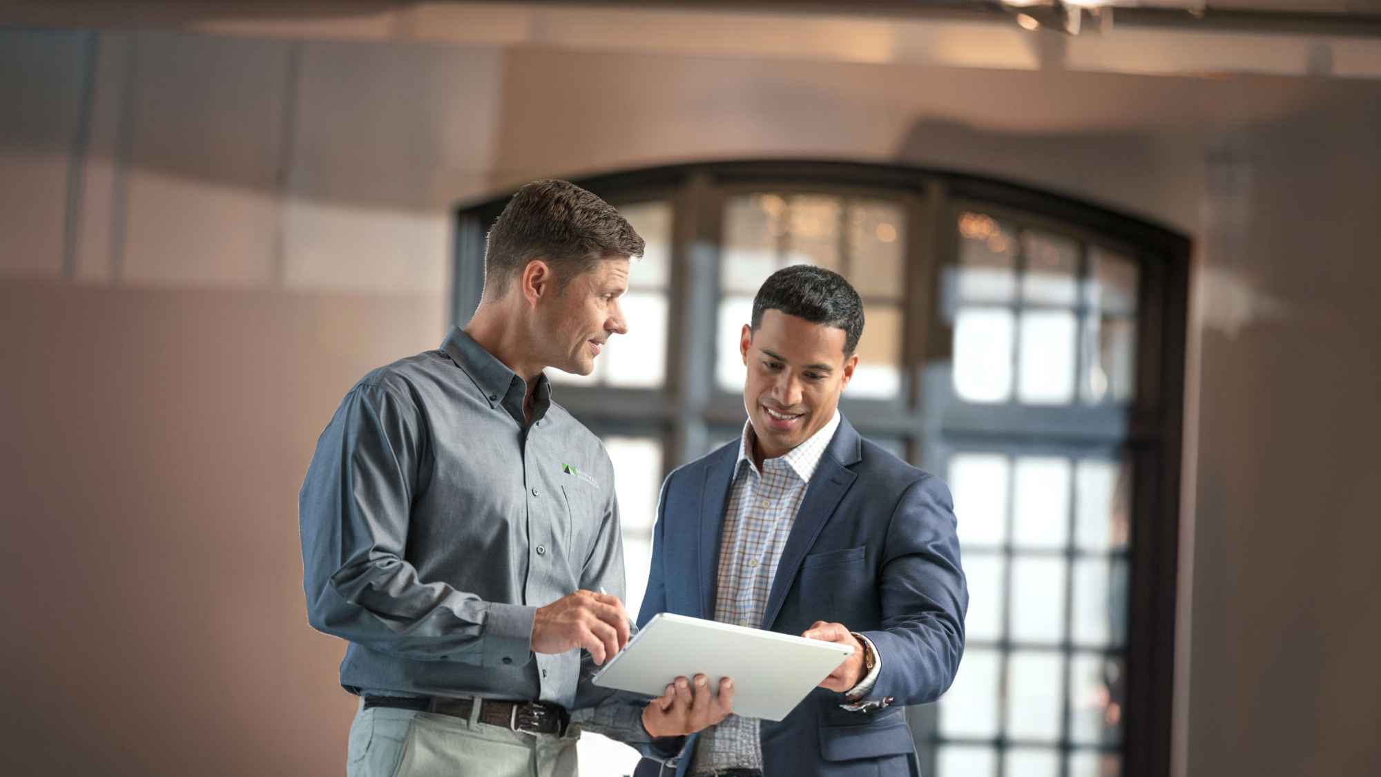 A renewal by andersen consultant working with a potential commercial customer looking over installation plans