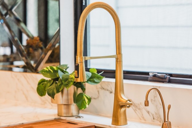 Breegan Jane's kitchen sink. It is gold with a marble counter.